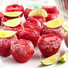 a close up shot of Strawberry Daiquiri Jello Shots topped with limes