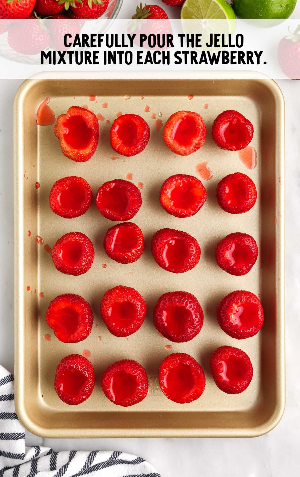 jello shot poured into each strawberry on a tray