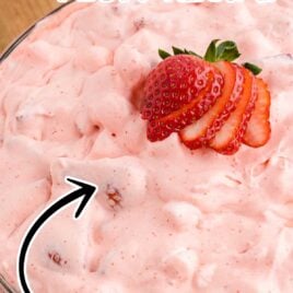 close up shot of Strawberry Fluff in a bowl topped with sliced strawberries