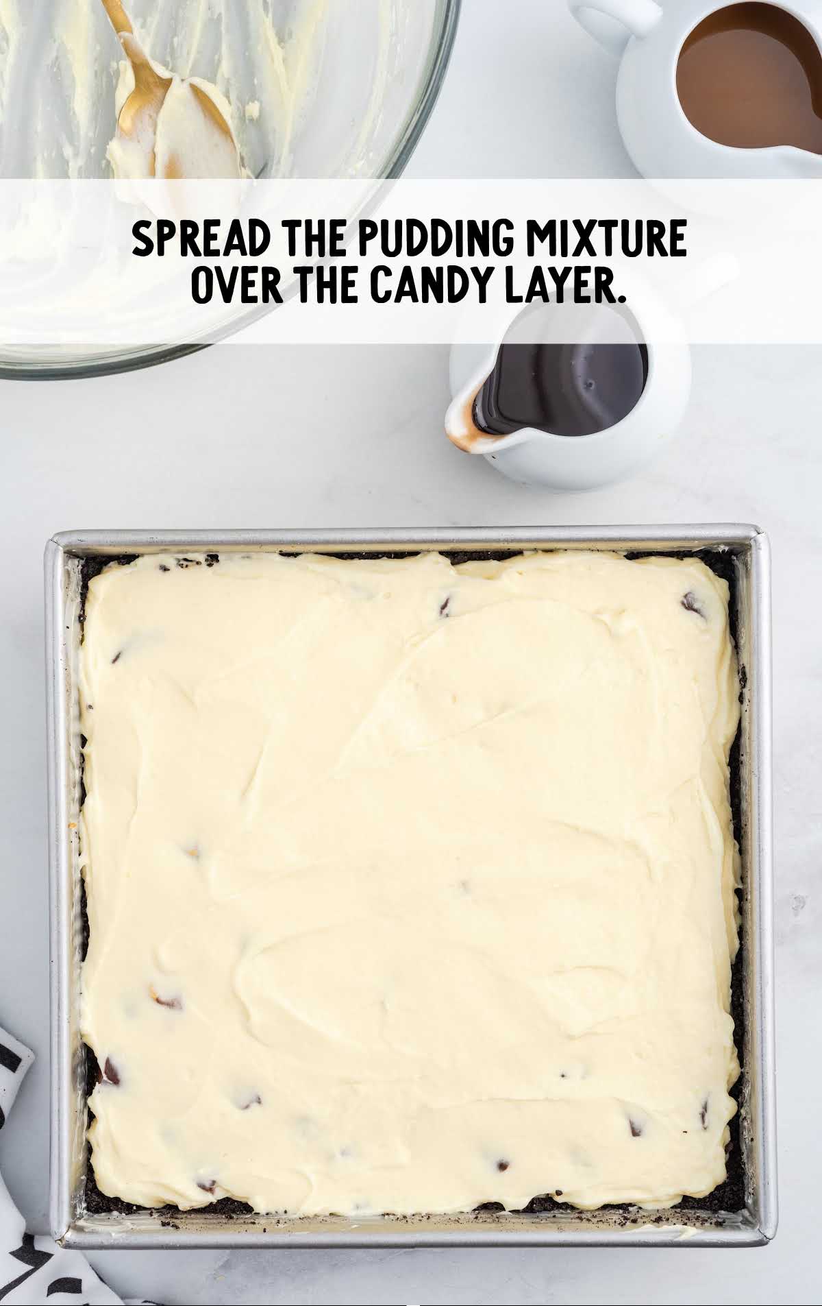 pudding mixture spread over the candy layer in a baking dish