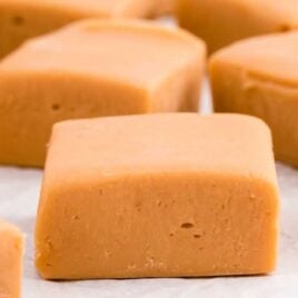 a close up shot of blocks of Butterscotch Fudge on parchment paper