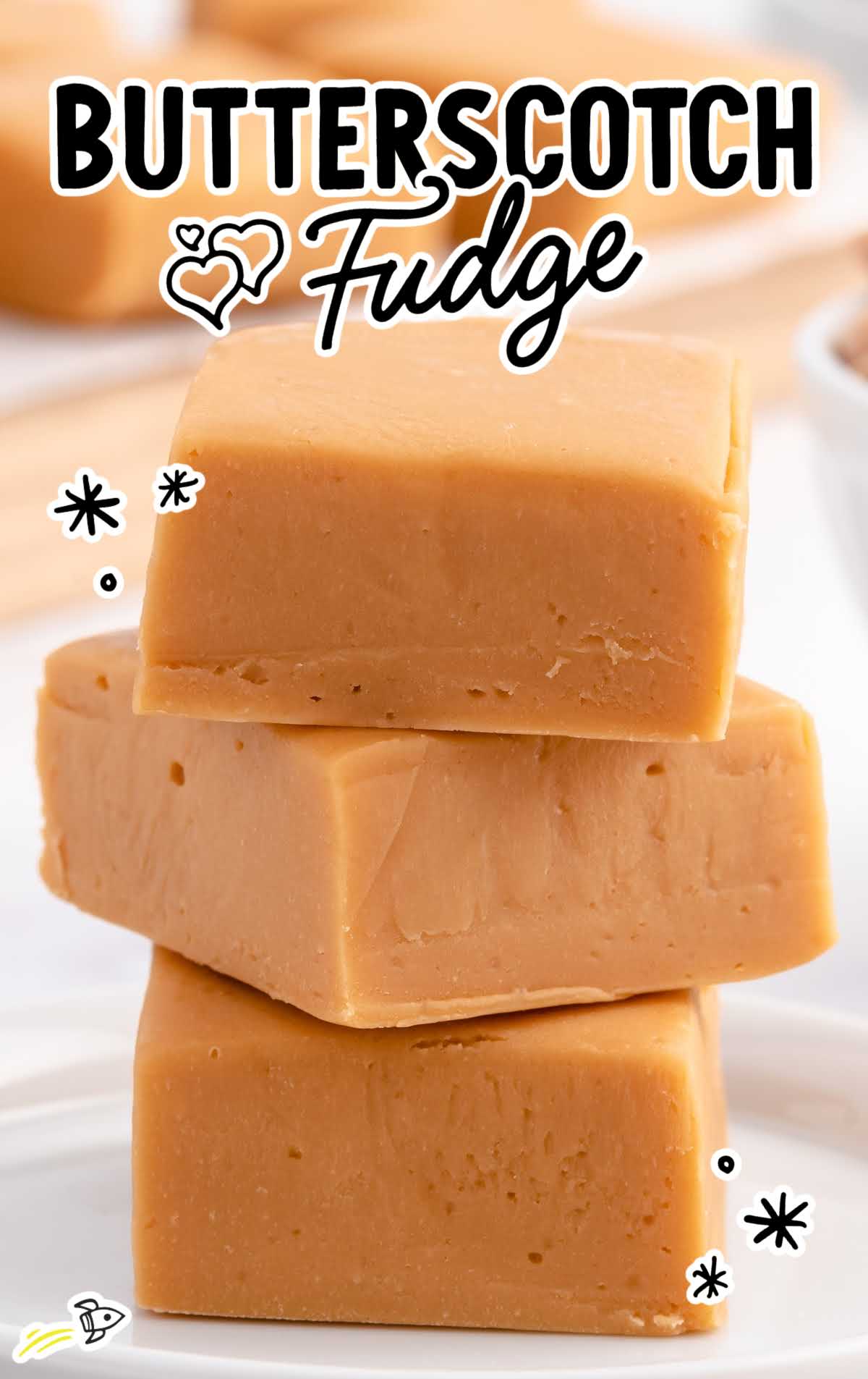 a close up shot of butterscotch fudge blocks stacked on top of each other on a plate