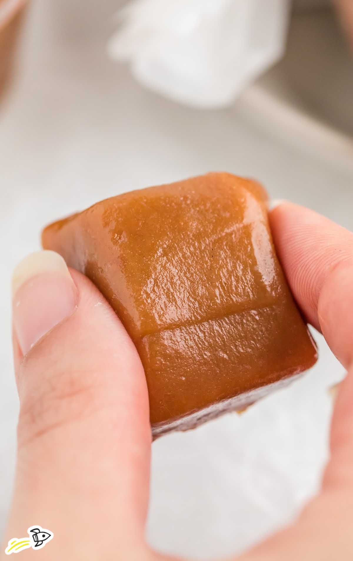 a close up shot of a caramel being picked up