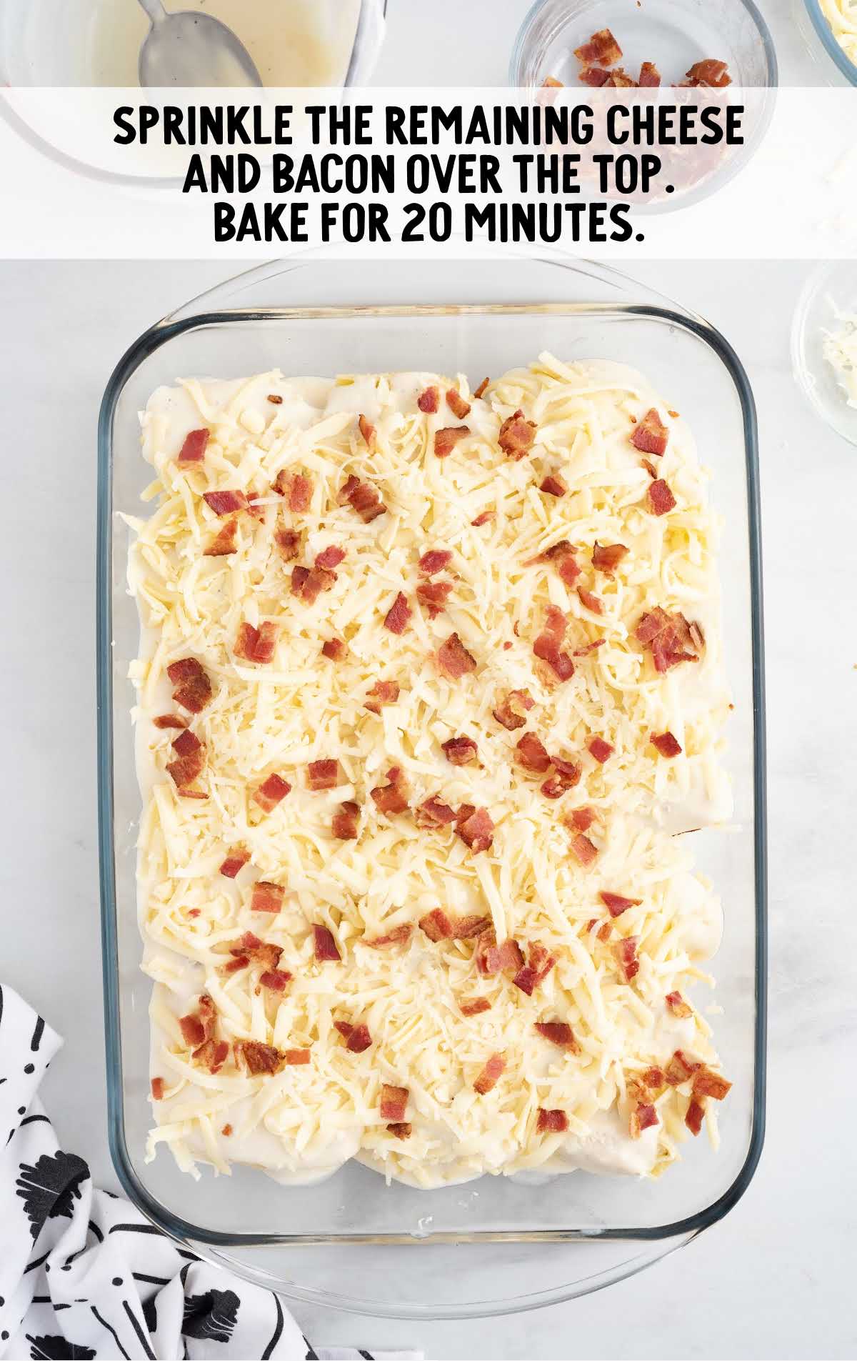 cheese and bacon sprinkled over the top of the shells in a baking dish