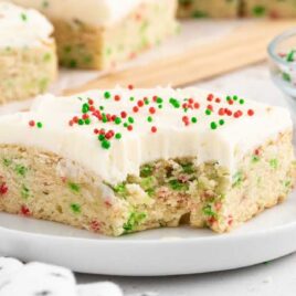 a close up shot of a slice of Christmas Sugar Cookie Bars on a plate