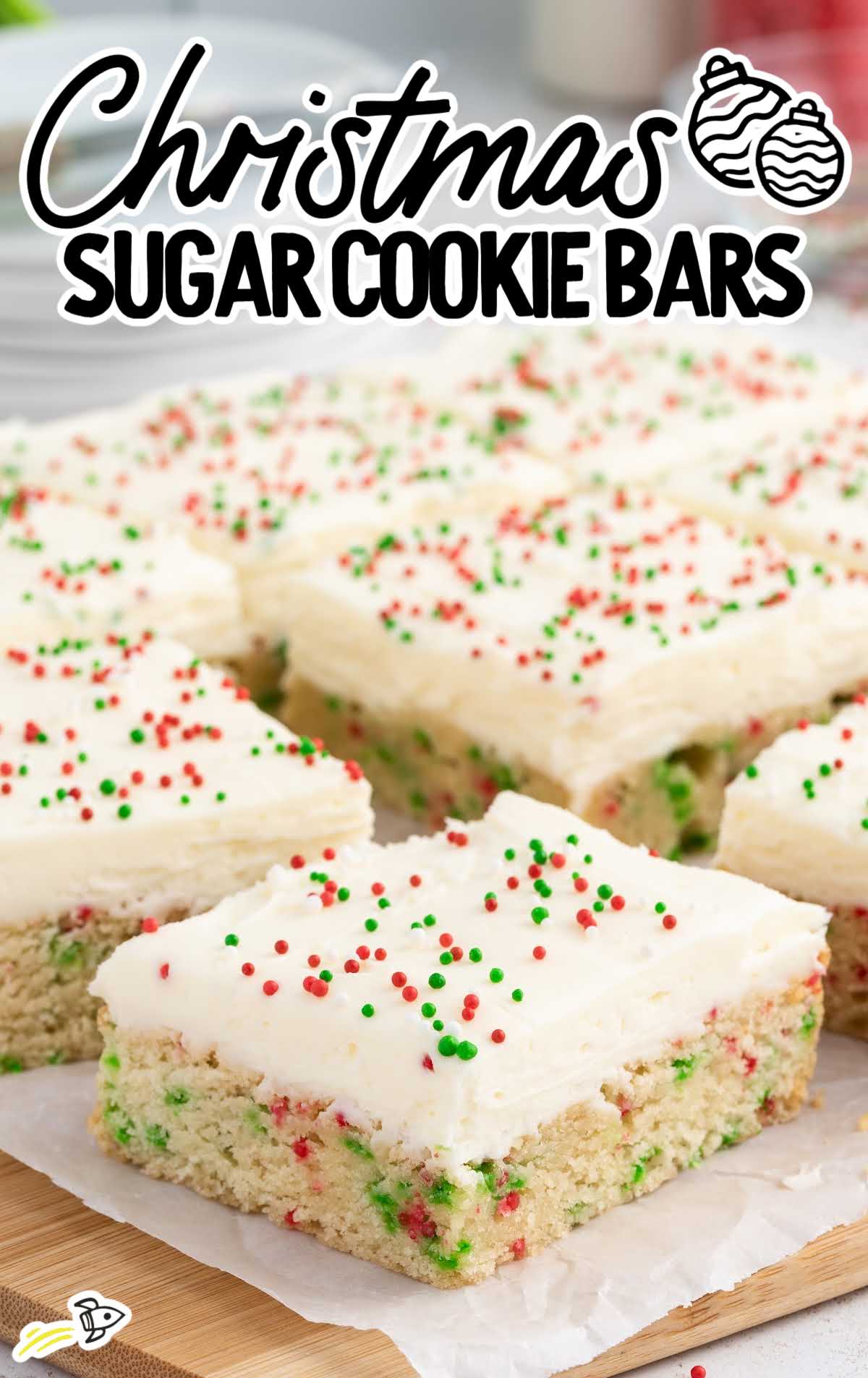 a close up shot of Christmas Sugar Cookie Bars on a wooden board