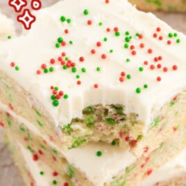 a close up shot of Christmas Sugar Cookie Bars on a wooden board stacked on top of each other