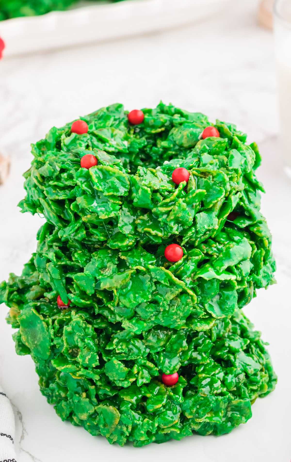 a close up shot of Christmas Wreath Cookies stacked on top of each other