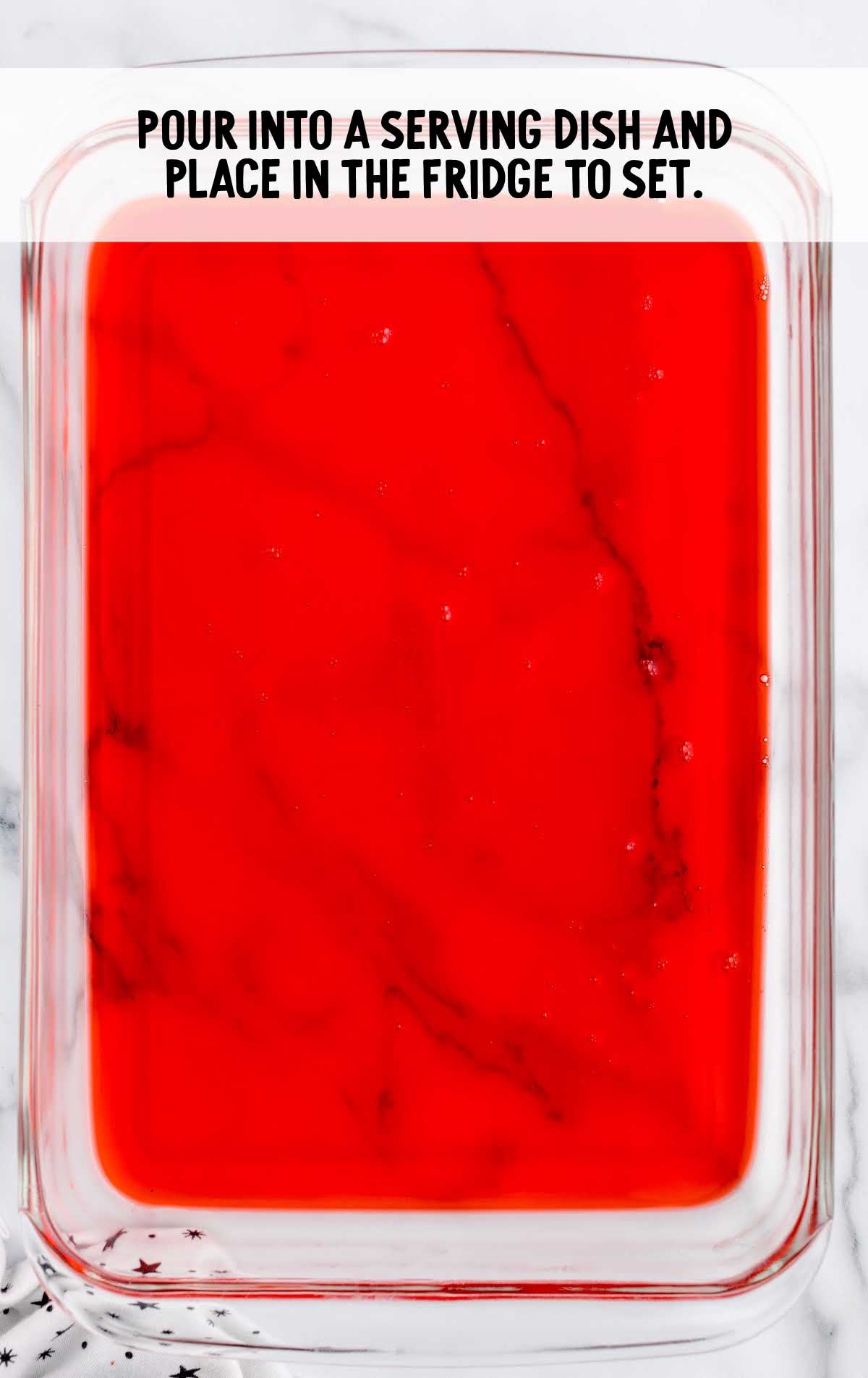 raspberry jello mixture poured in a baking dish