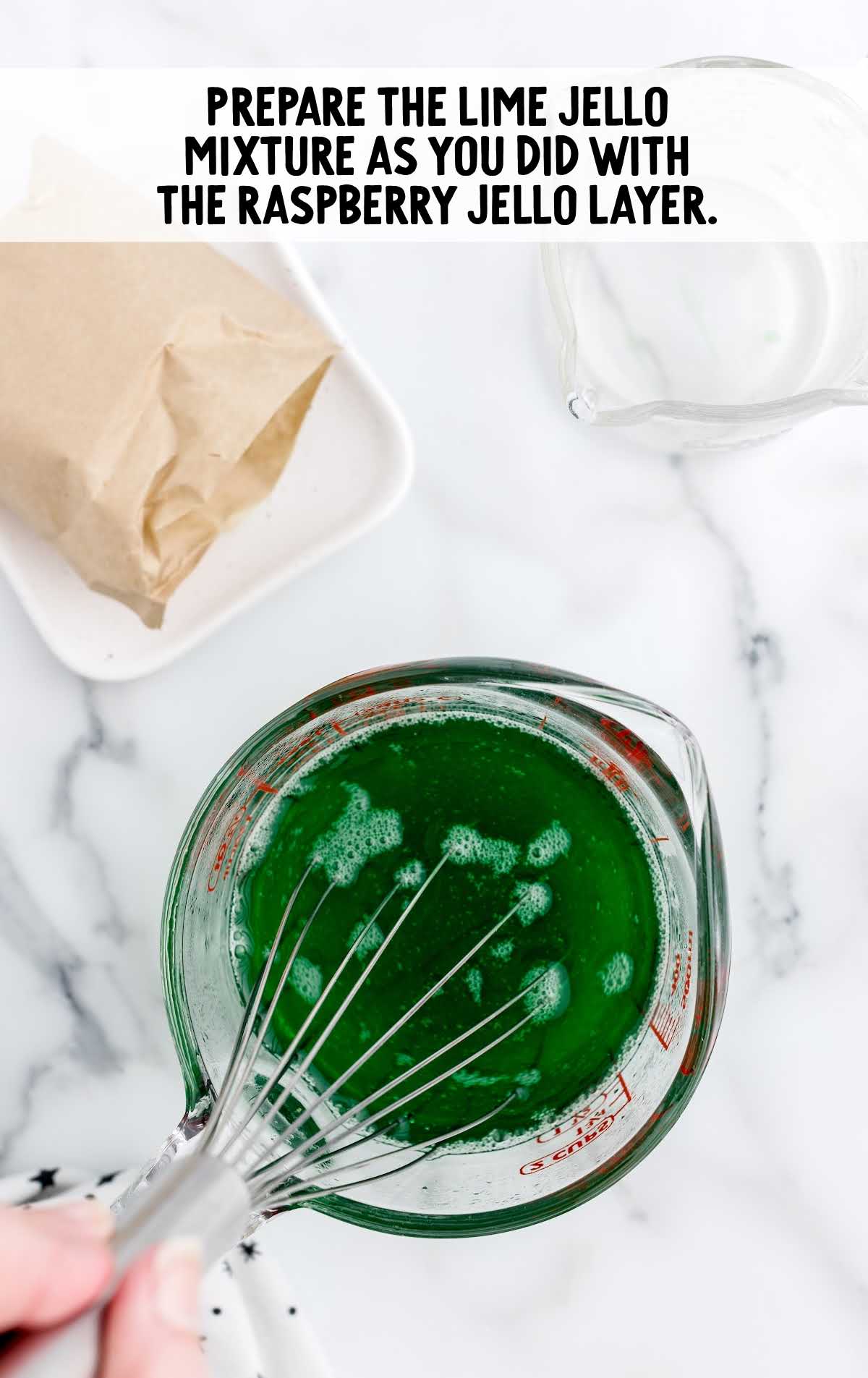 lime jello mixture whisked in a measuring cup