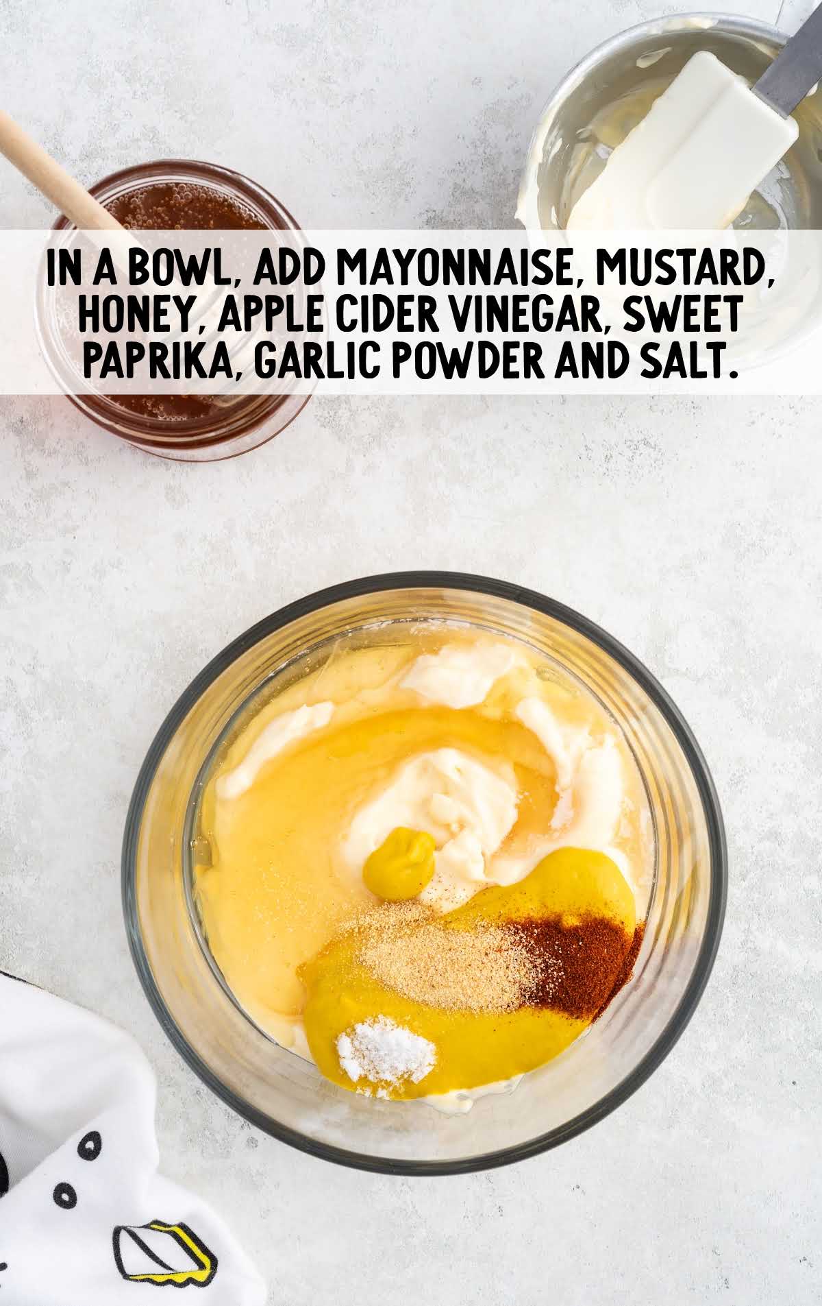 mayonnaise, mustard, honey, apple cider vinegar, sweet paprika, garlic powder, and salt folded in a bowl