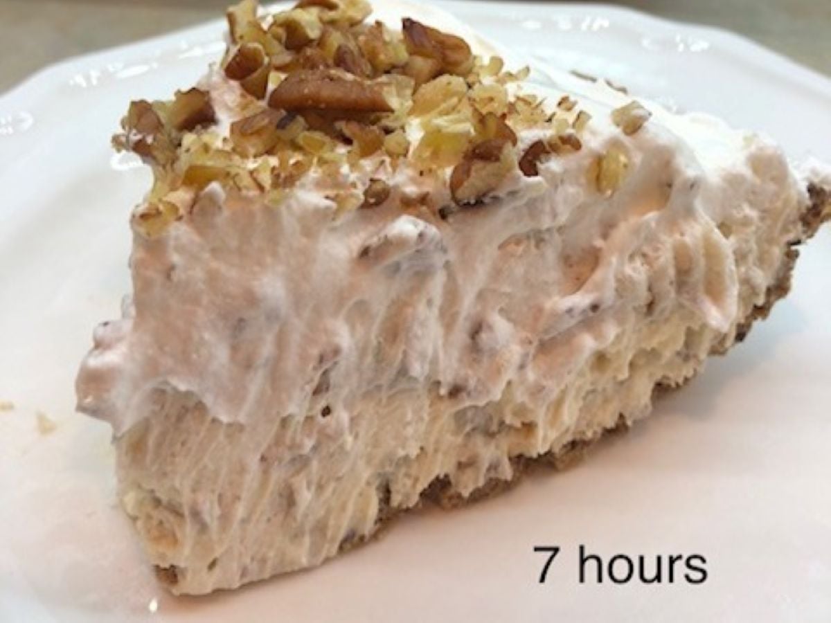 A slice of creamy Pecan Cream Pie topped with chopped nuts sits on a white plate. The pie appears fluffy with a thick layer of whipped topping. Text on the image reads 7 hours.