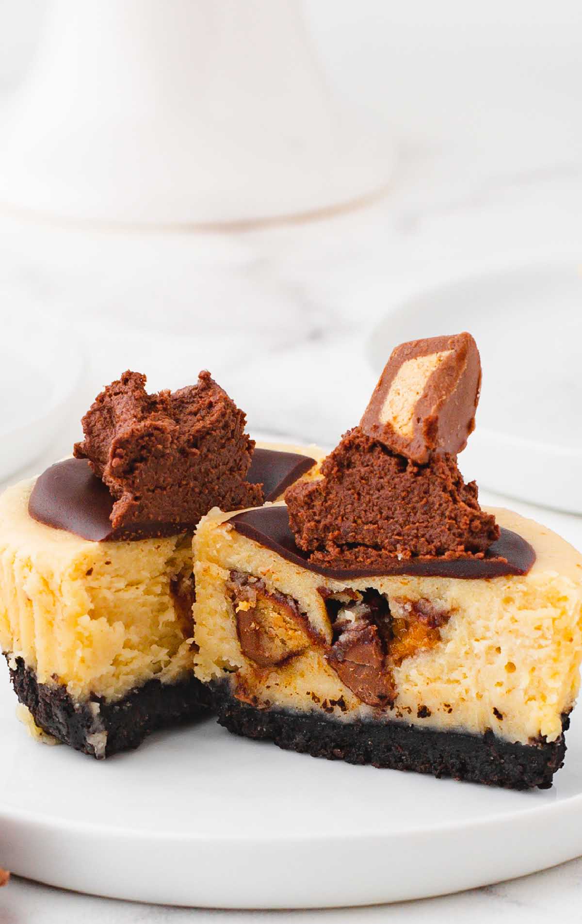 a close up shot of Reese’s Peanut Butter Cup Mini Cheesecake on a plate split in half
