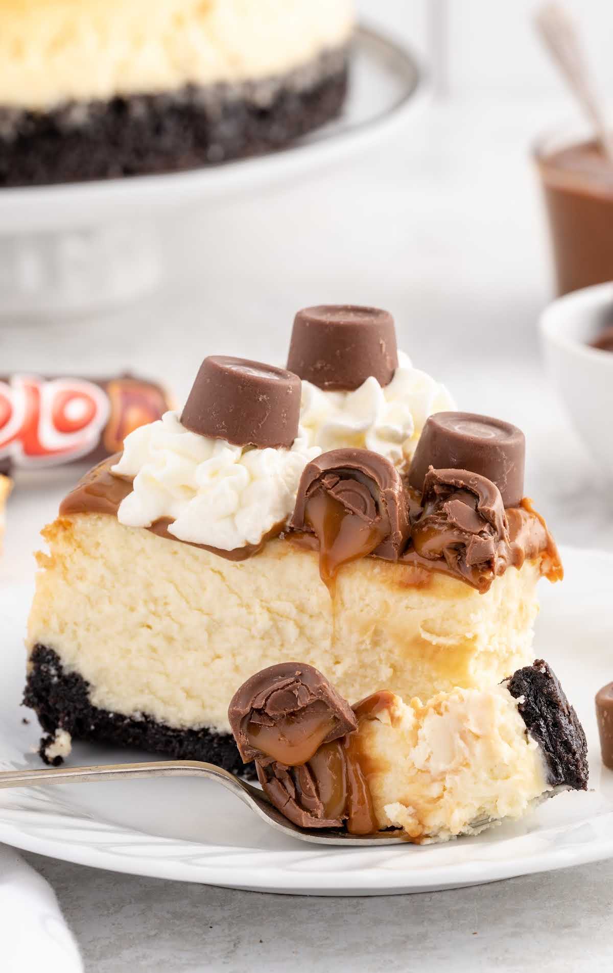 a close up shot of a slice of Rolo Cheesecake with a piece on a fork