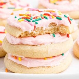 a close up shot of Soft Sugar Cookies stacked on top of each other with a bite taken out of one