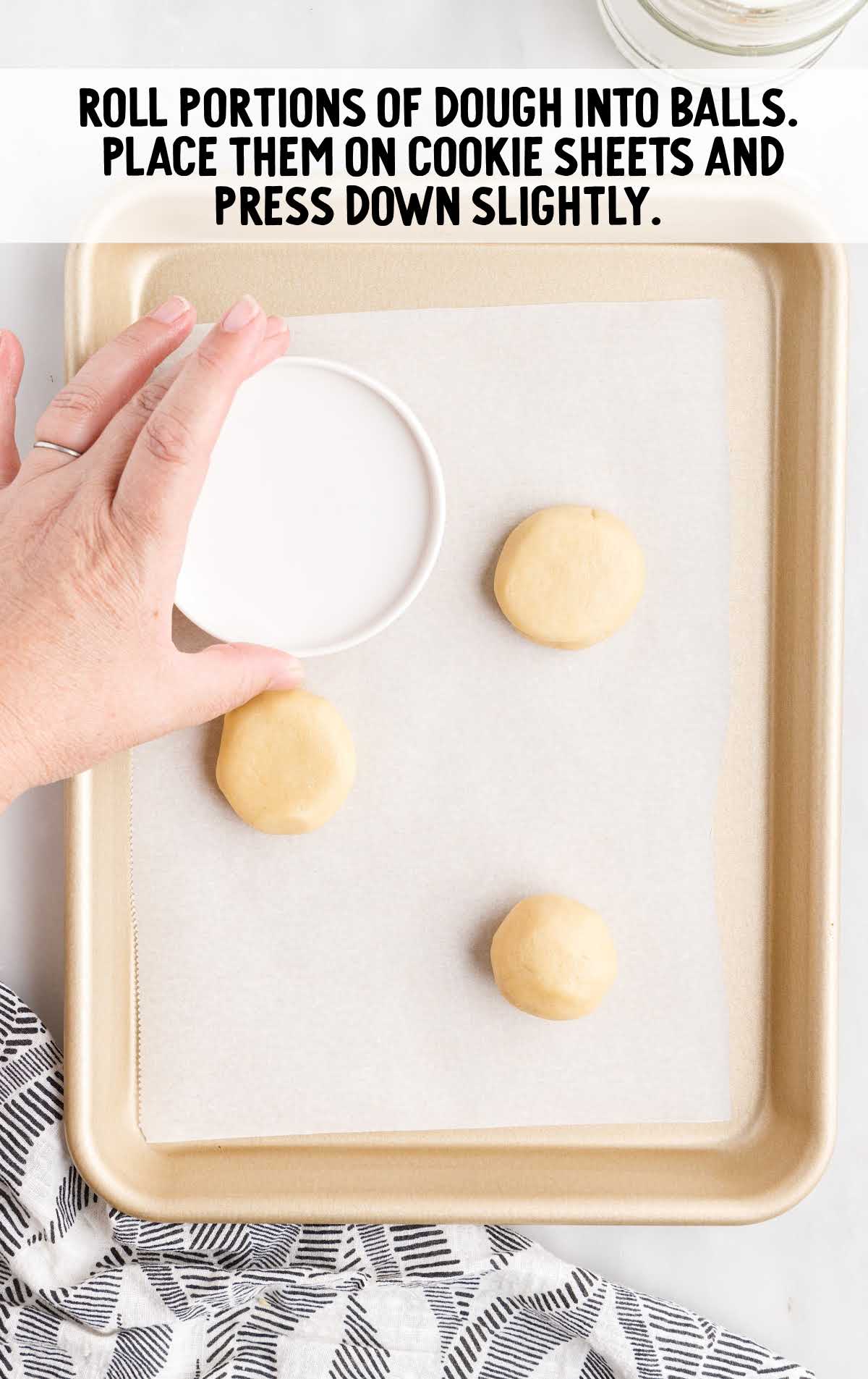 press dough ball slightly into the cookie sheet