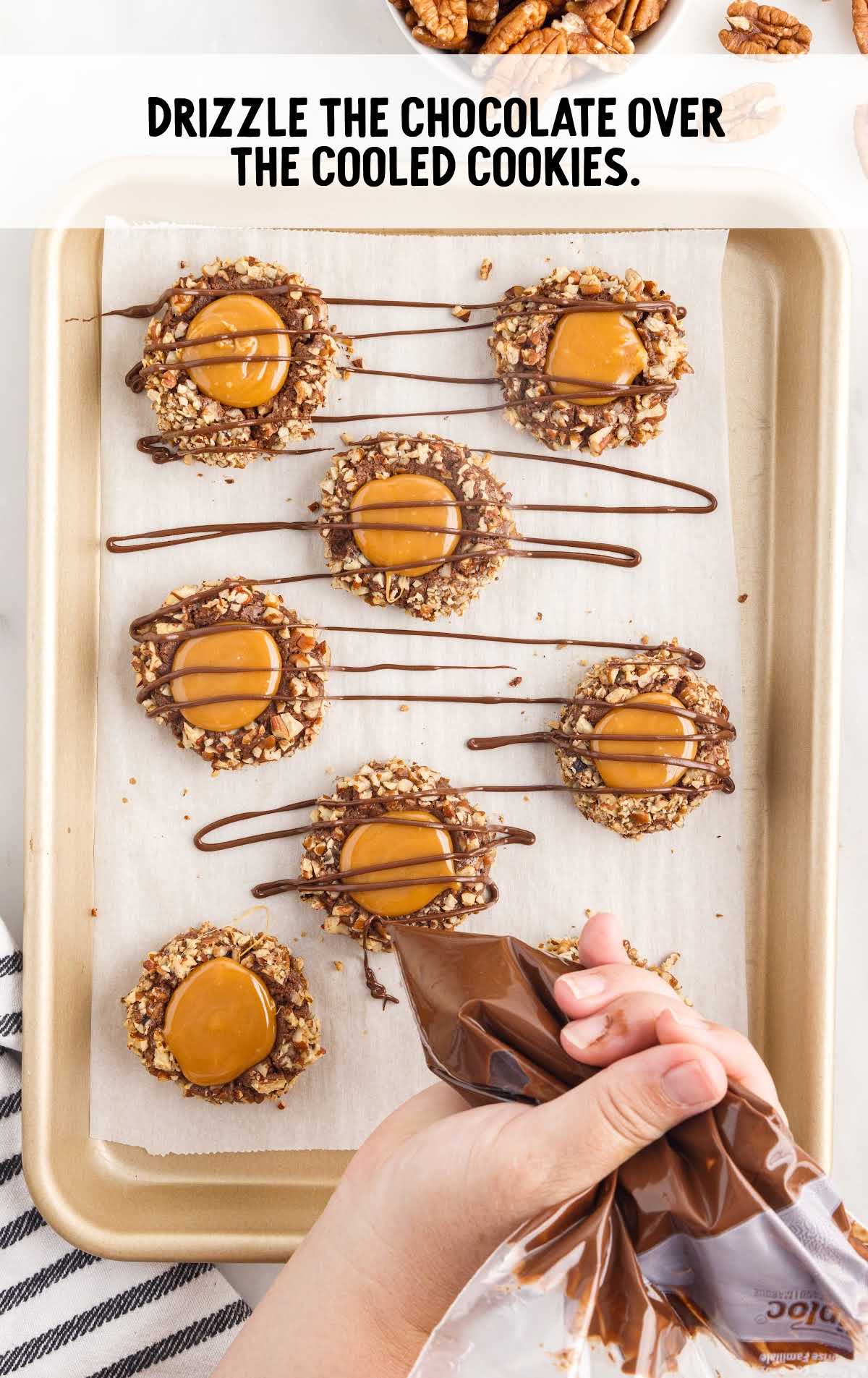 chocolate drizzled over the cookies on a tray