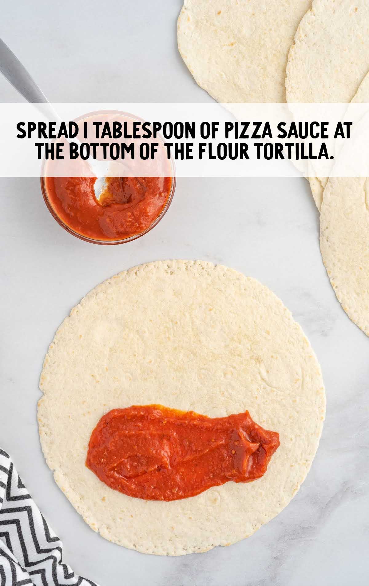 pizza sauce spread on the bottom of the tortilla
