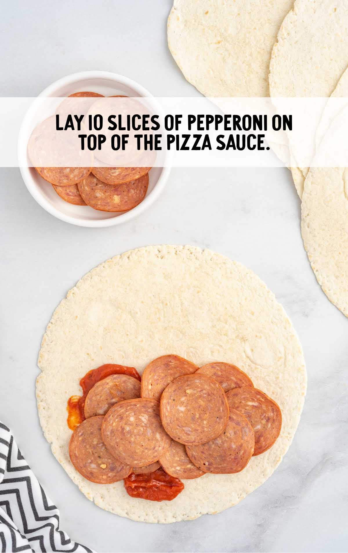 10 slices of pepperoni laid on top of the pizza sauce