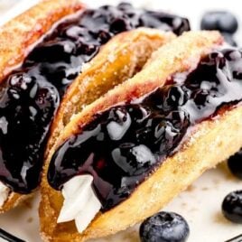 a close up shot of Blueberry Cheesecake Tacos on a plate