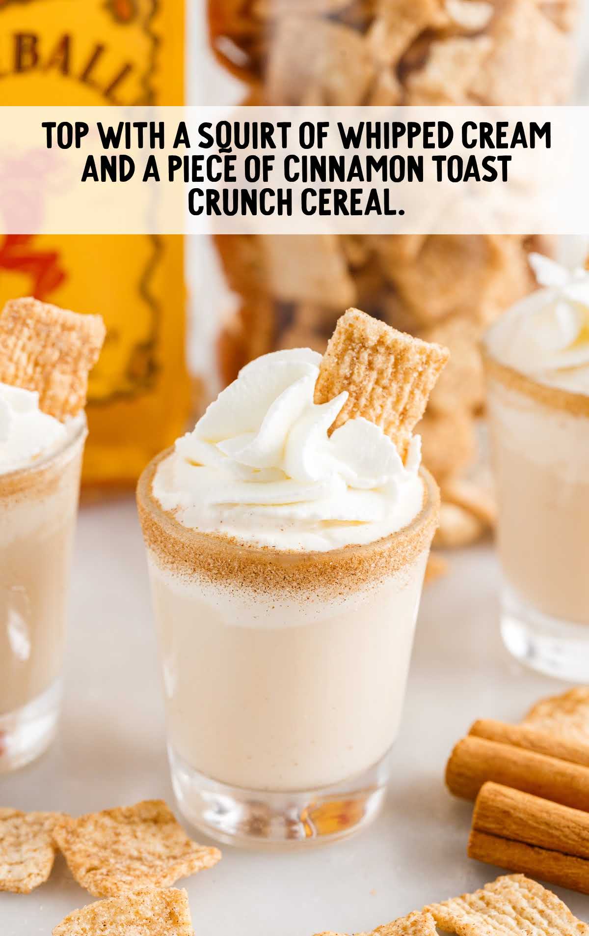 whipped cream and a piece of cinnamon toast crunch garnished on top of the shot