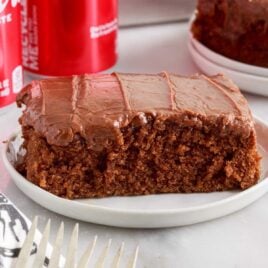 a close up shot of a slice of Coca Cola Cake on a plate