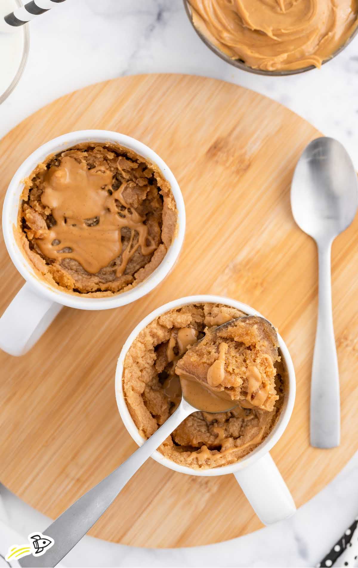 overhead shot of Peanut Butter Cake in a Mug on a wooden board