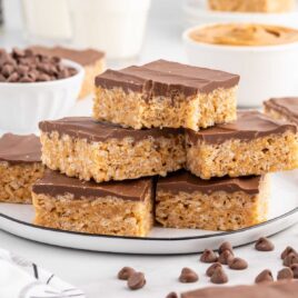 a close up shot of Peanut Butter Rice Krispie Treats stacked on top of each other on a plate