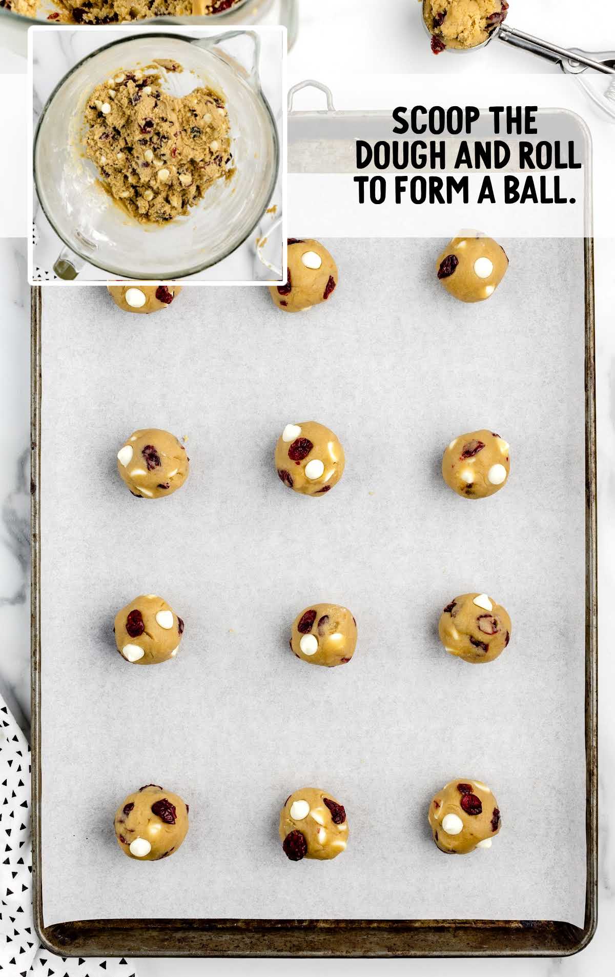 cookie dough scooped into balls and placed on a parchment lined baking sheet