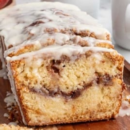 Moist apple fritter bread with cinnamon swirl and glaze drizzled on top.