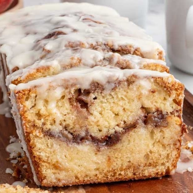Moist apple fritter bread with cinnamon swirl and glaze drizzled on top.