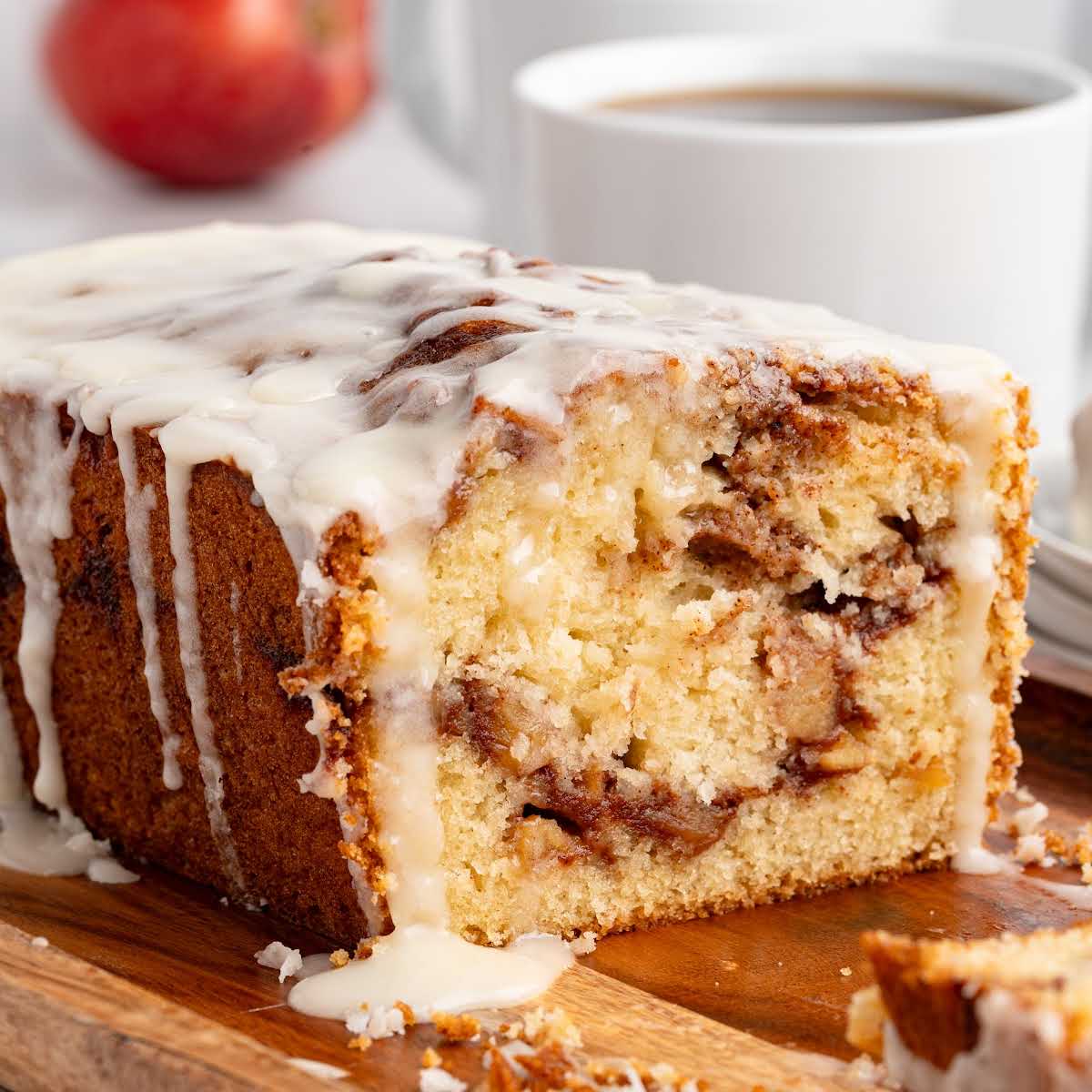 Glazed apple fritter bread loaf with apples and cinnamon, served with coffee.