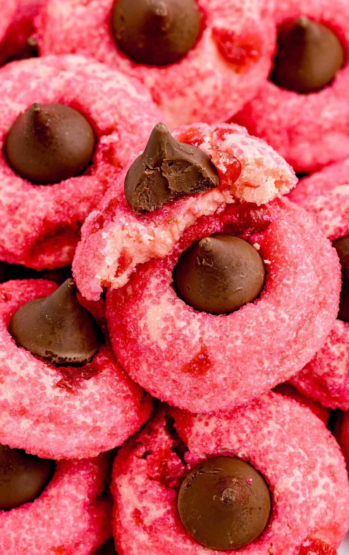 close up shot of Cherry Kiss Cookies stacked on top of each other with one having a bite taken out of it