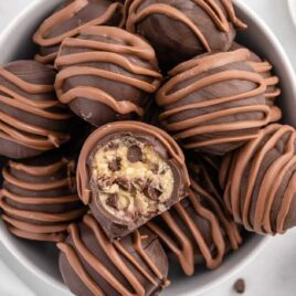 overhead shot of Cookie Dough Truffles in a bowl with one having a bite taken out