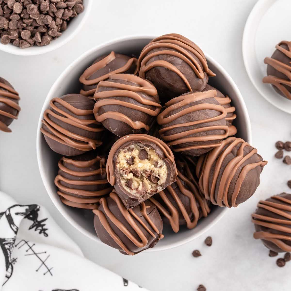overhead shot of Cookie Dough Truffles in a bowl with one having a bite taken out