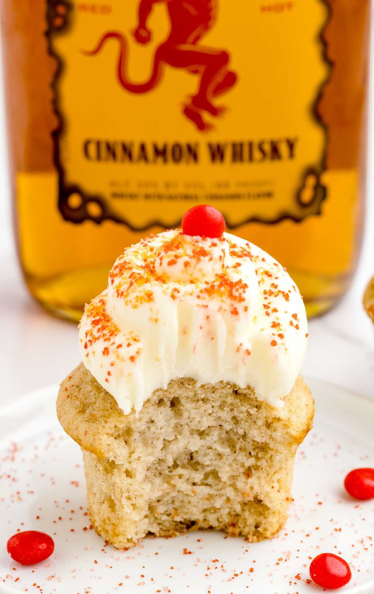 a close up shot of a Fireball Cupcake on a plate with a bite taken out of it