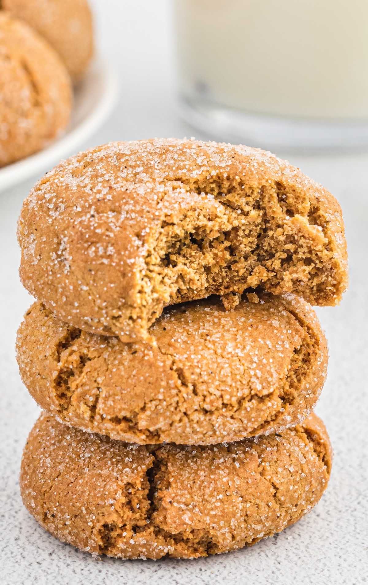 a close up shot of Gingersnap Cookies stacked on top of each other and one having a bite taken out of it