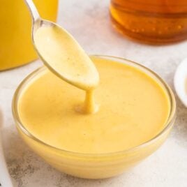 a bowl of honey mustard sauce with a spoon