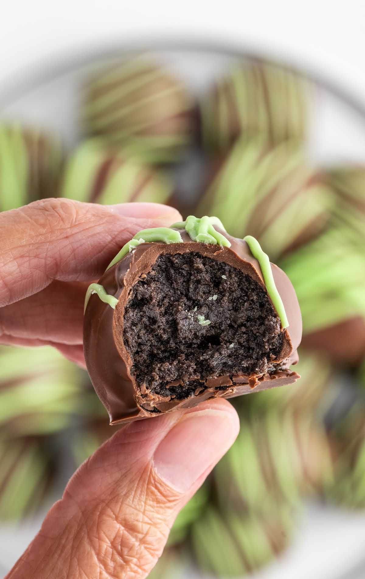 a close up shot of a Mint Oreo Truffle with a bite taken out of it