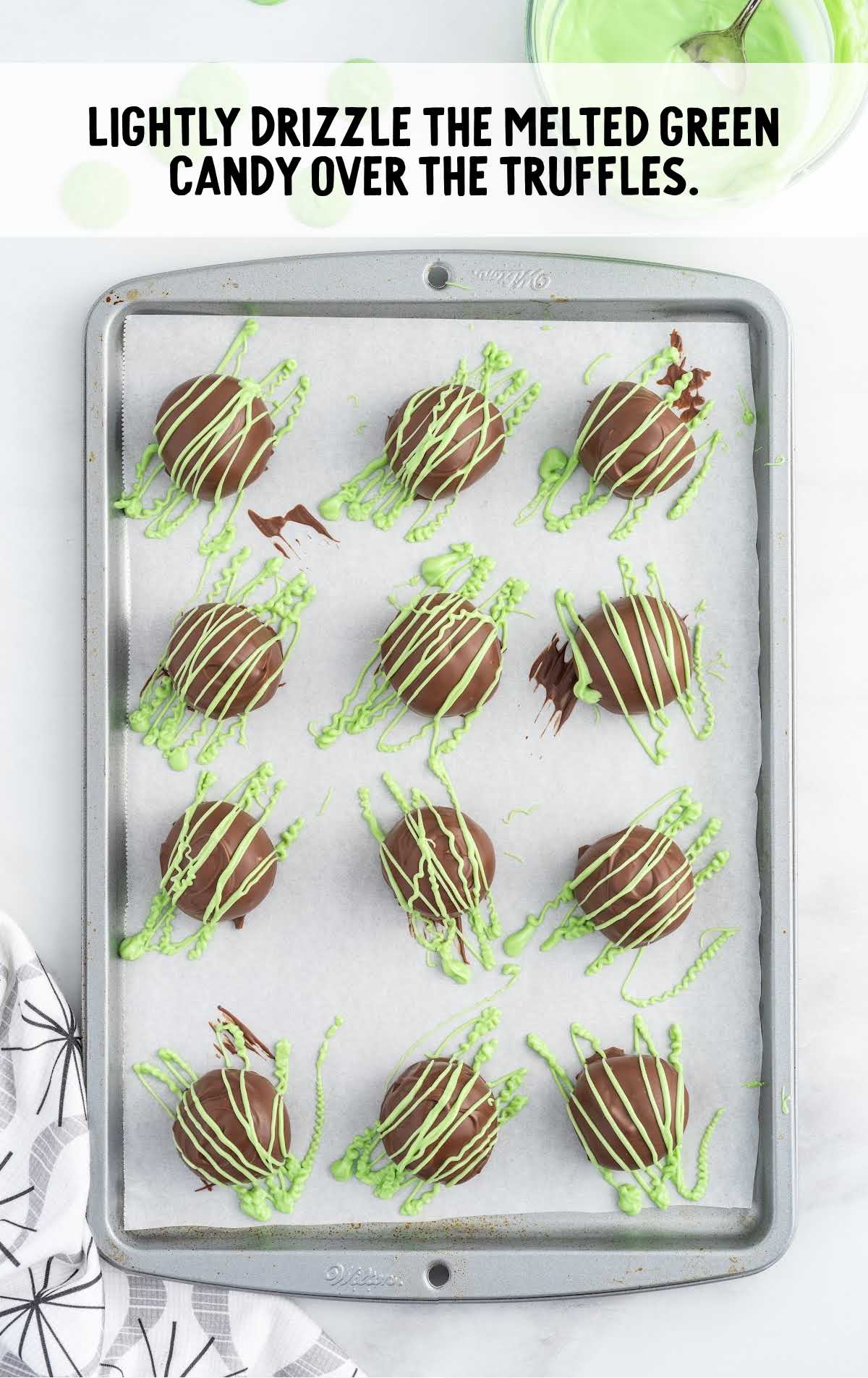 melted green candy drizzled over the truffles