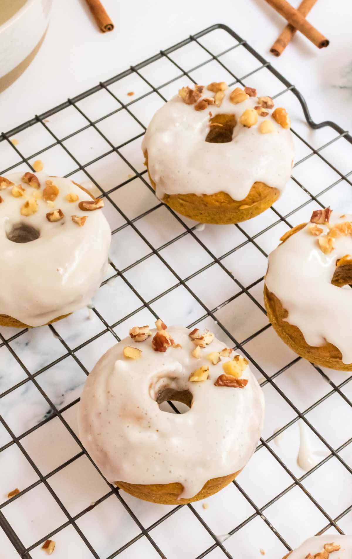 a close up shot of Baked Pumpkin Donuts on a cooling rack