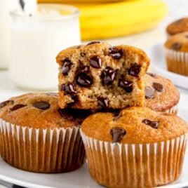 a close up shot of Banana Chocolate Chip Muffins on a plate with a bite taken out of it