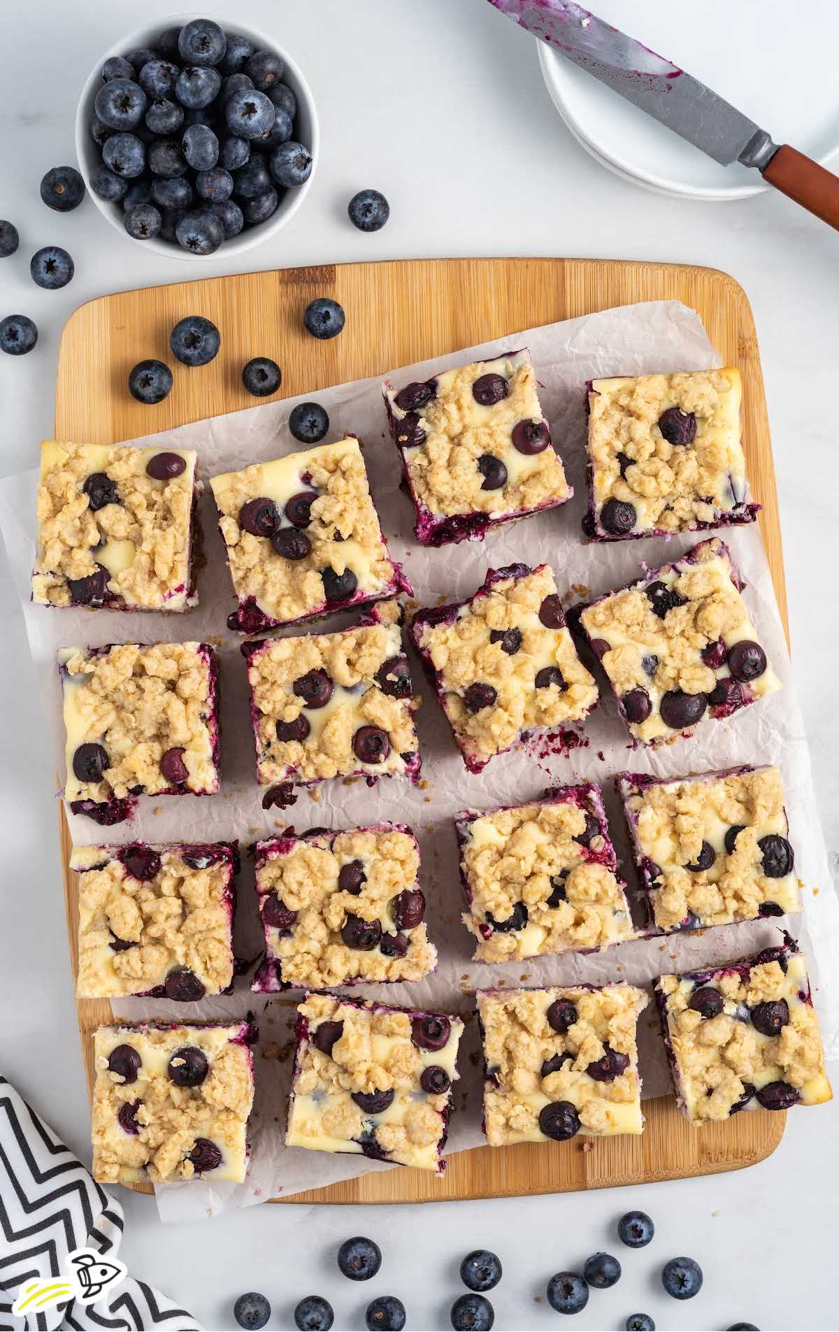 overhead shot of Blueberry Cheesecake Bars on a wooden board
