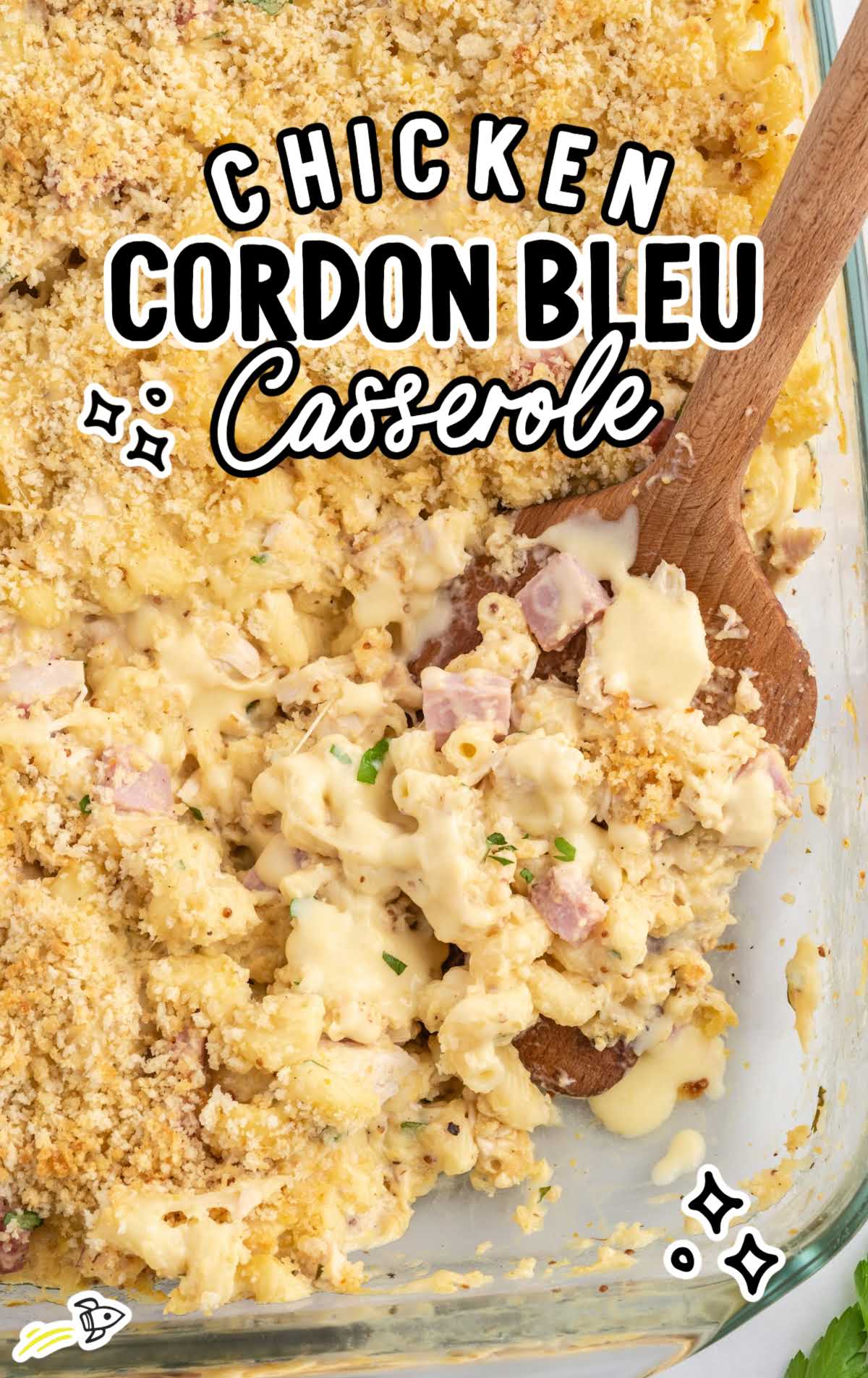 overhead shot of Chicken Cordon Bleu Casserole in a baking dish with a wooden spoon grabbing a piece