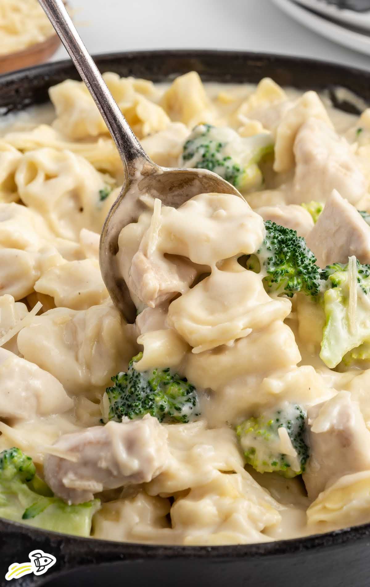 a close up shot of Chicken Tortellini on a skillet with a fork grabbing a piece