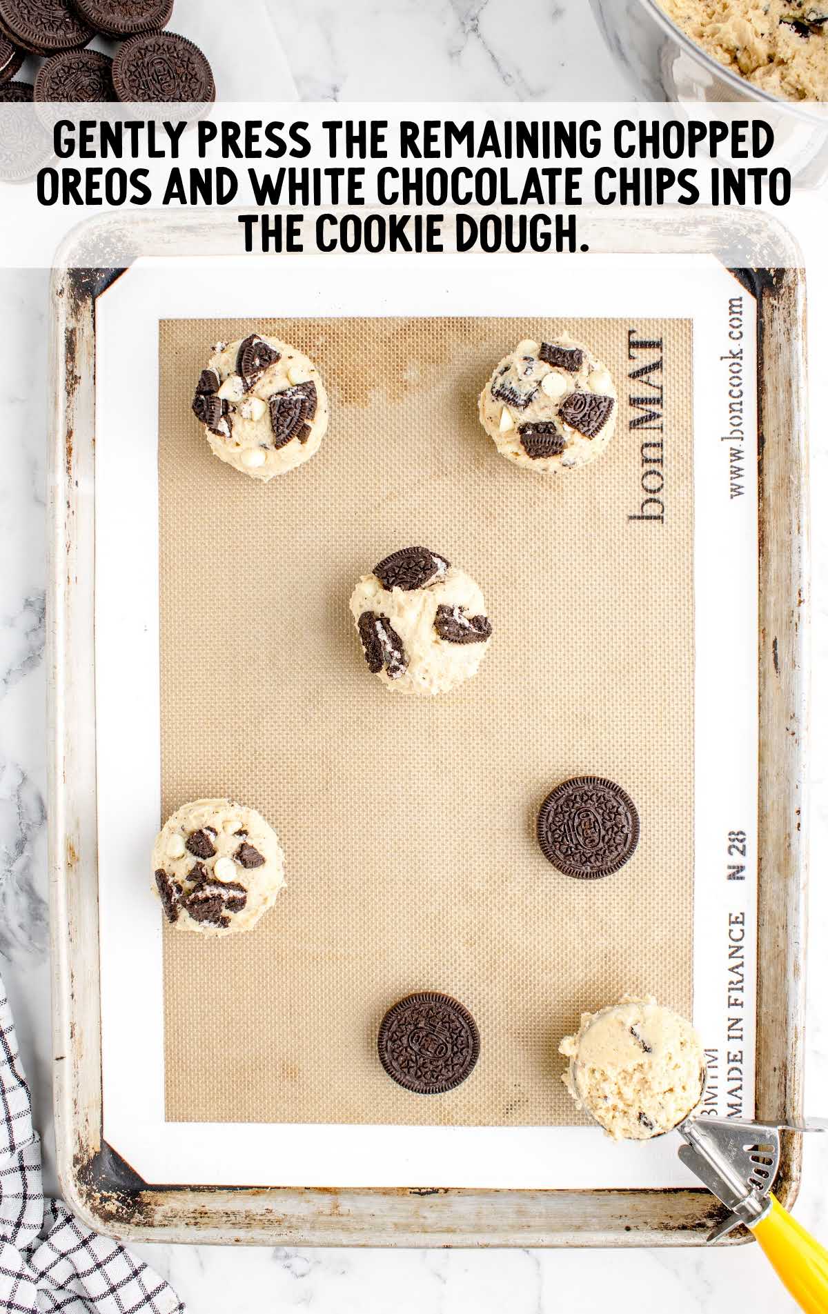 chopped oreos and white chocolate chips pressed into the cookie dough