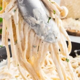 a close up shot of Cream Cheese Pasta Sauce with noodles being picked up by tongs