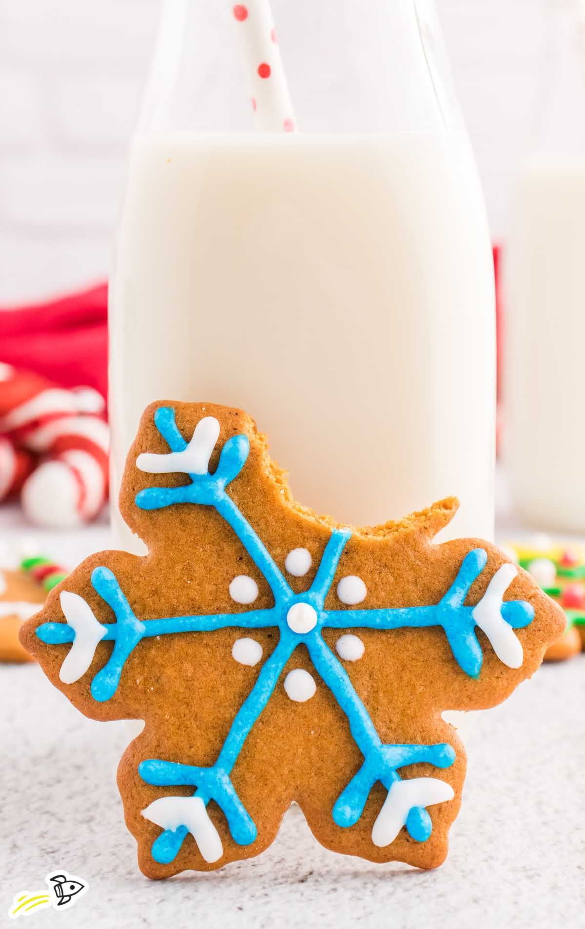 a close up shot of Gingerbread Cookie with a milk bottle behind it