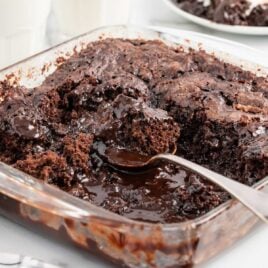 a close up shot of Pudding Cake with a spoon grabbing a piece in a baking dish