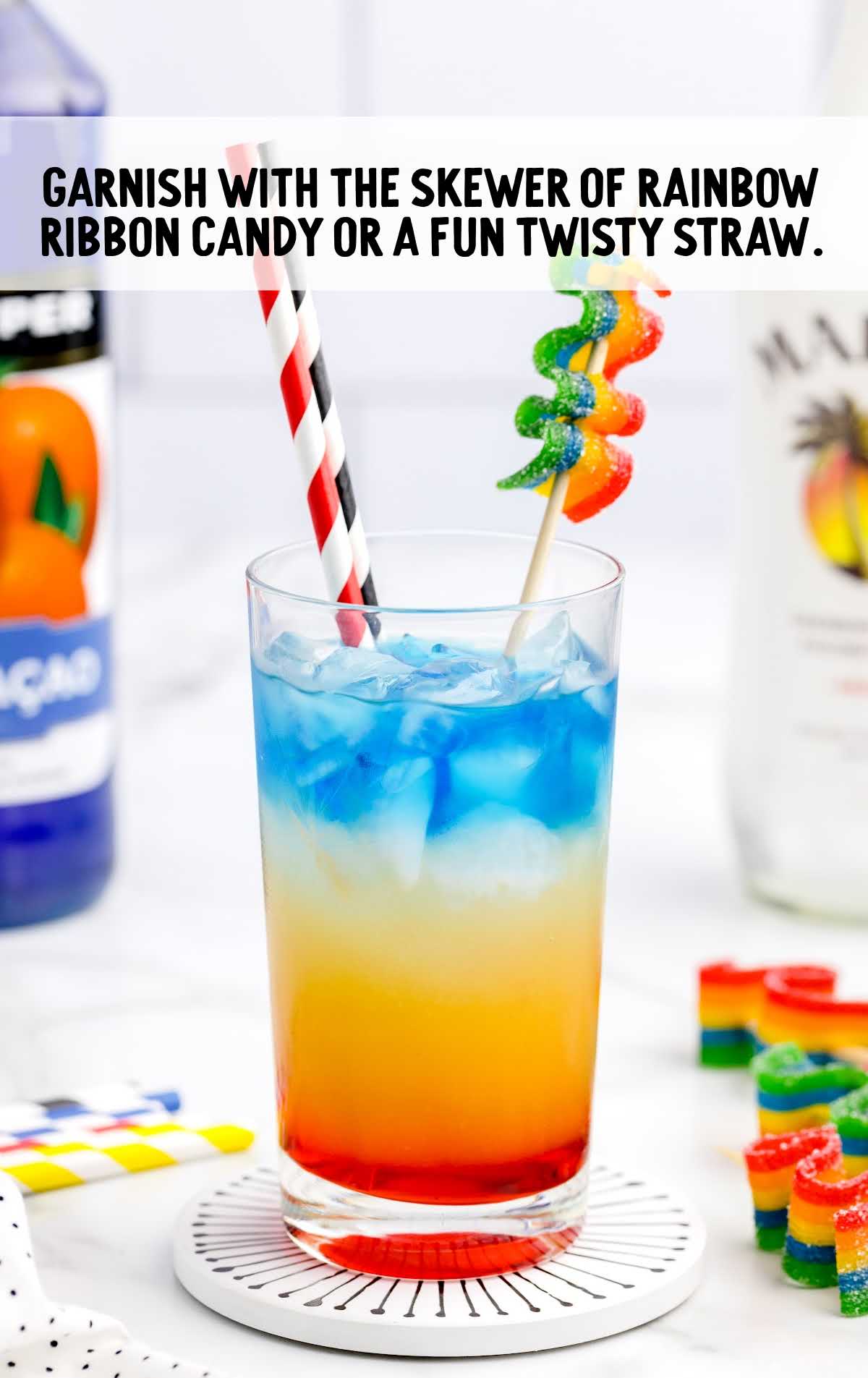 Rainbow Cocktail garnished with twisty straw and rainbow candy